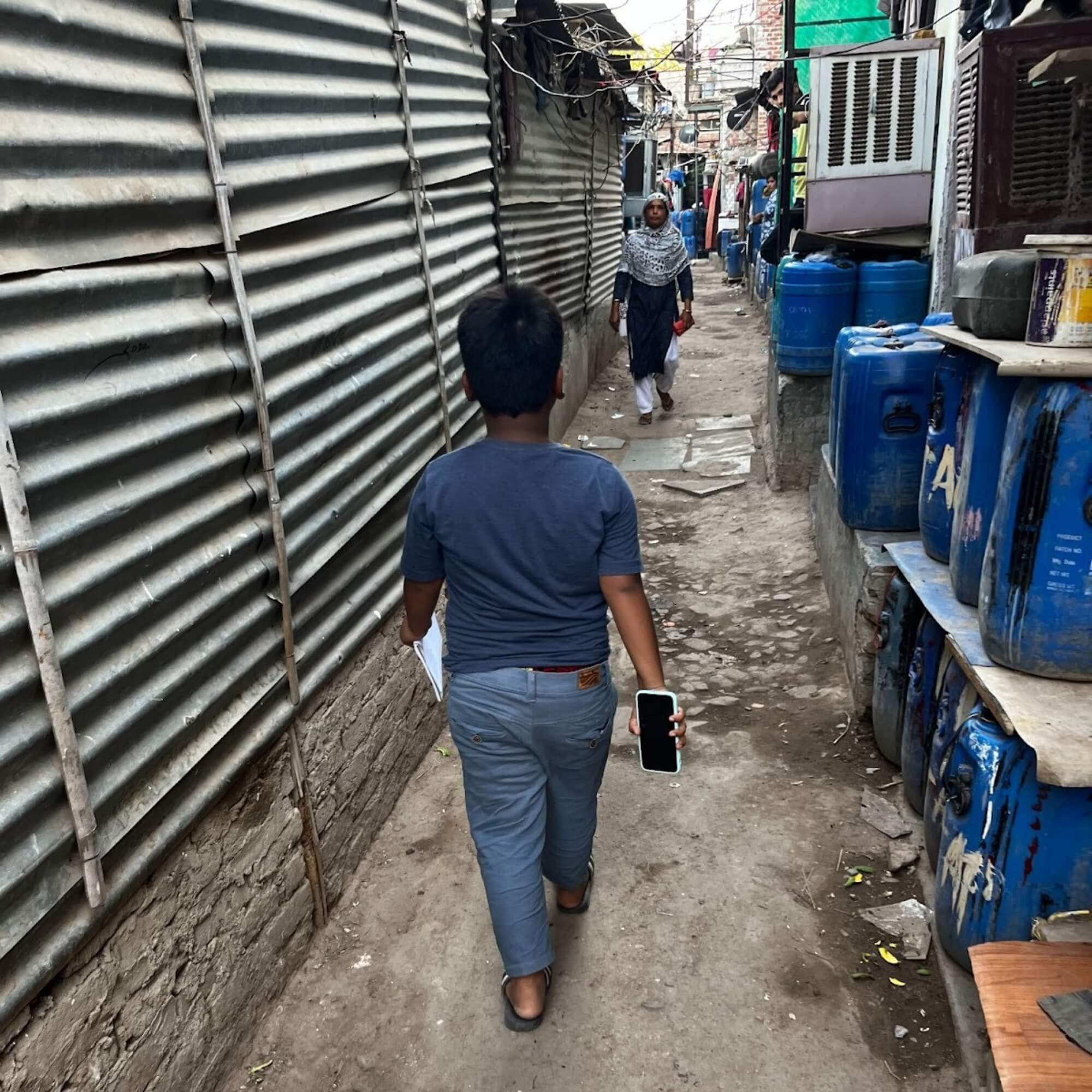 Child walking down a street holding a phone to be used as a camera