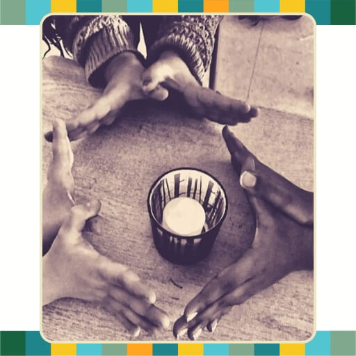Hands of children gathered together at a table.