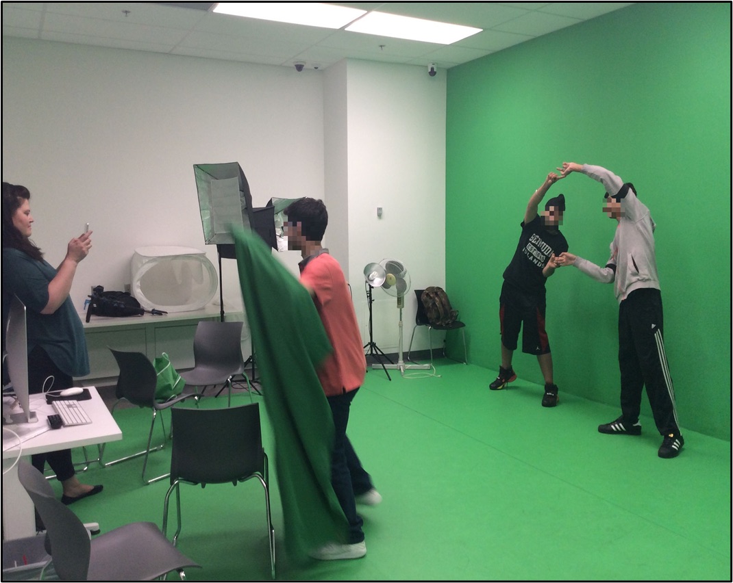 Youth collaborating in front of a green screen.